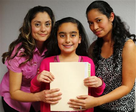 Teresa Villanueva (L) and her 11-year-old daughter Laritza receive help on their charter school application from Barrio Logan College Institute counselor Jennifer Pena (R) in San Diego